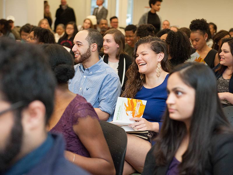 A seated audience laughing during an lecture event.